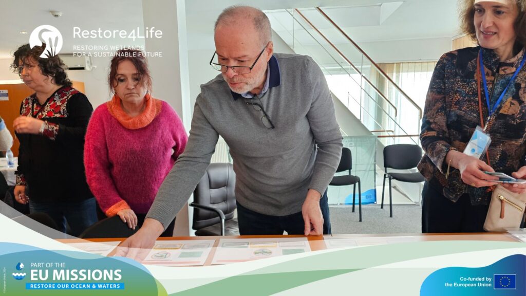 Group of people gathering around a table to discuss an activity from the workshop